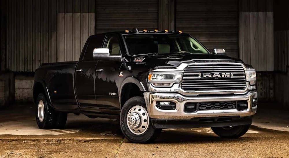 A black 2020 Ram 3500 is shown parked in front of a farm.