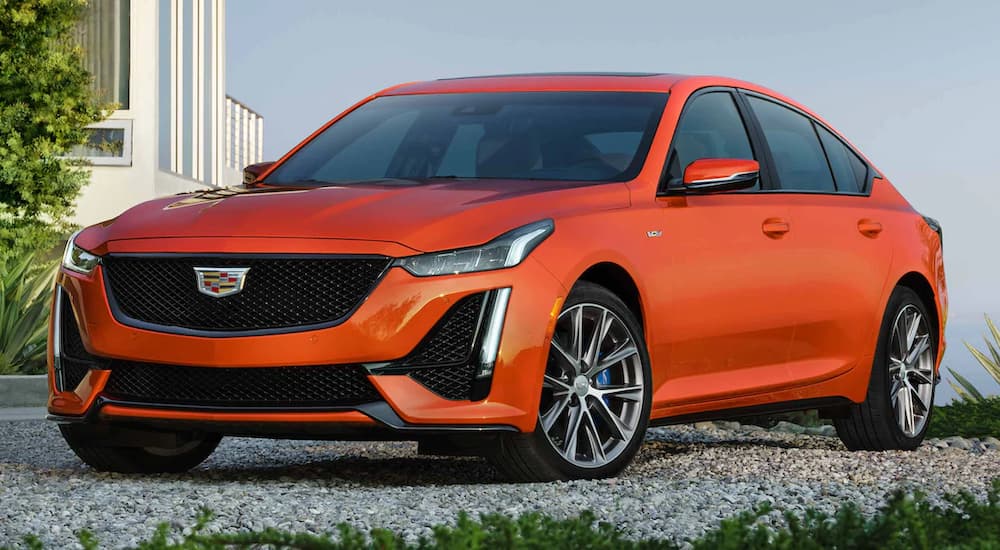 An orange 2022 Cadillac CT5-V is shown parked from a front angle on gravel.