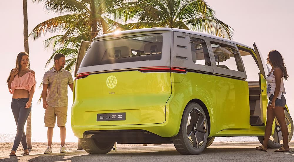A green Volkswagen ID.Buzz concept is shown from a rear angle at a beach.