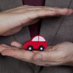 A person is shown holding a toy car as they contemplate how to sell your car.