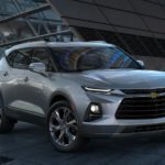 A silver 2022 Chevy Blazer is shown from the side parked in front of a modern building at night.