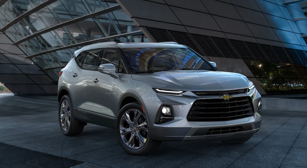 A silver 2022 Chevy Blazer is shown from the side parked in front of a modern building at night.