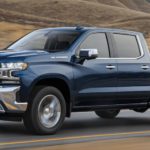 A blue 2022 Chevy Silverado 1500 Limited is shown from the side driving on an open road.