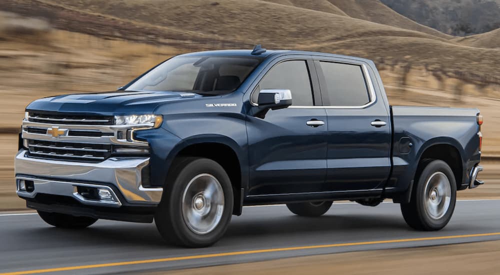 A blue 2022 Chevy Silverado 1500 Limited is shown from the side driving on an open road.