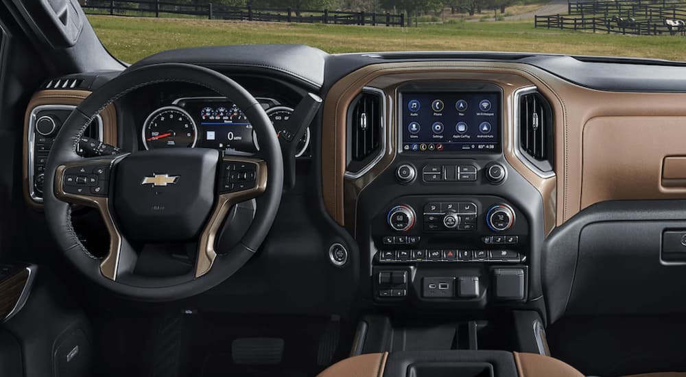 The black and brown interior of a 2022 Chevy Silverado 1500 Limited shows the steering wheel and infotainment screen.