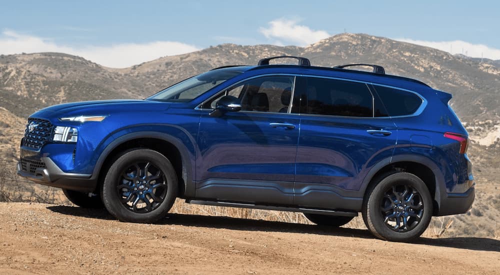 A blue 2020 Hyundai Santa Fe is shown from the side parked in the desert.