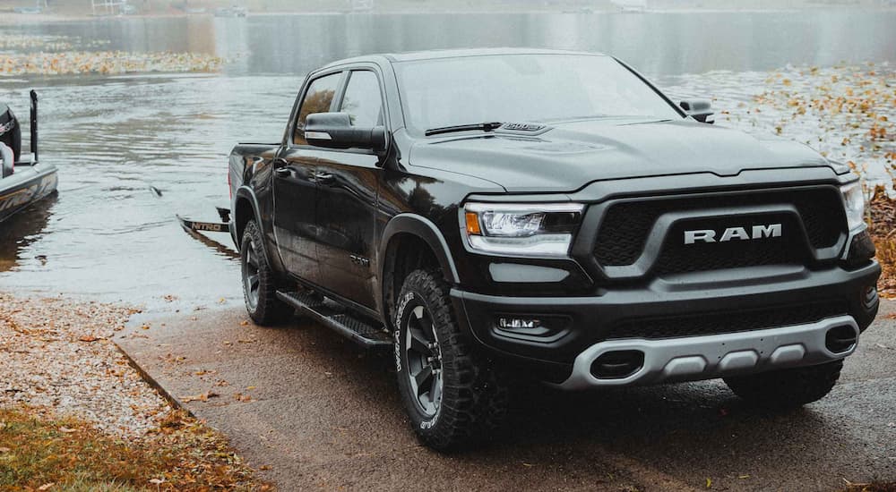 A black 2022 Ram 1500 is shown from the front with a boat trailer submerged in a body of water.