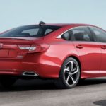 A red 2022 Honda Accord Hybrid Sport SE is shown from the side parked in an open lot.