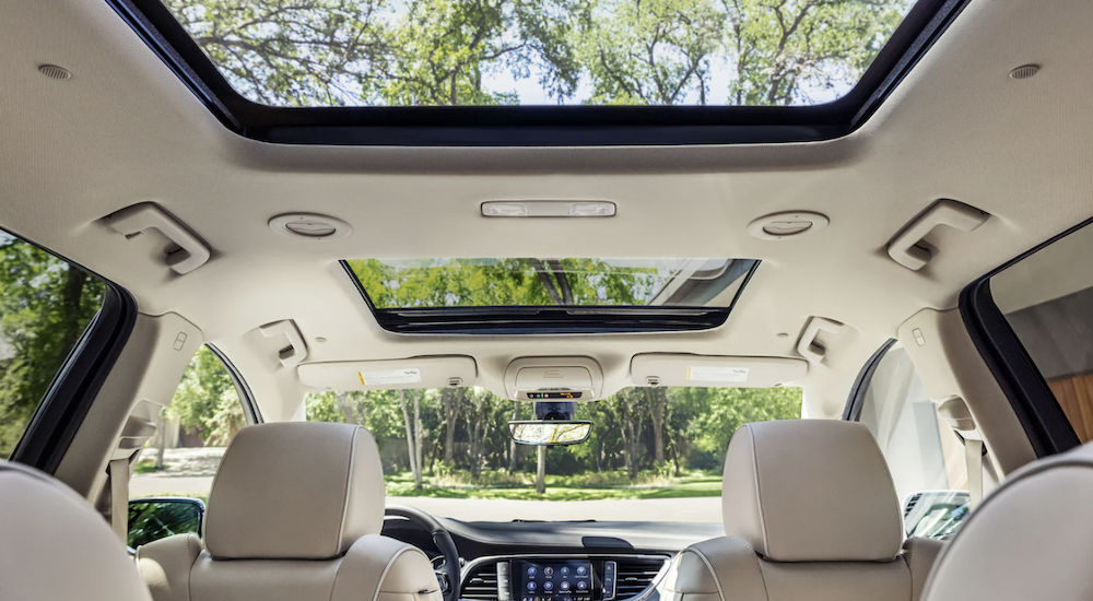 The white interior of a 2022 Buick Enclave shows the moon roof and front seats.