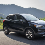 A black 2022 Buick Encore is shown from the side parked in front of a mountain after leaving a Buick dealer.