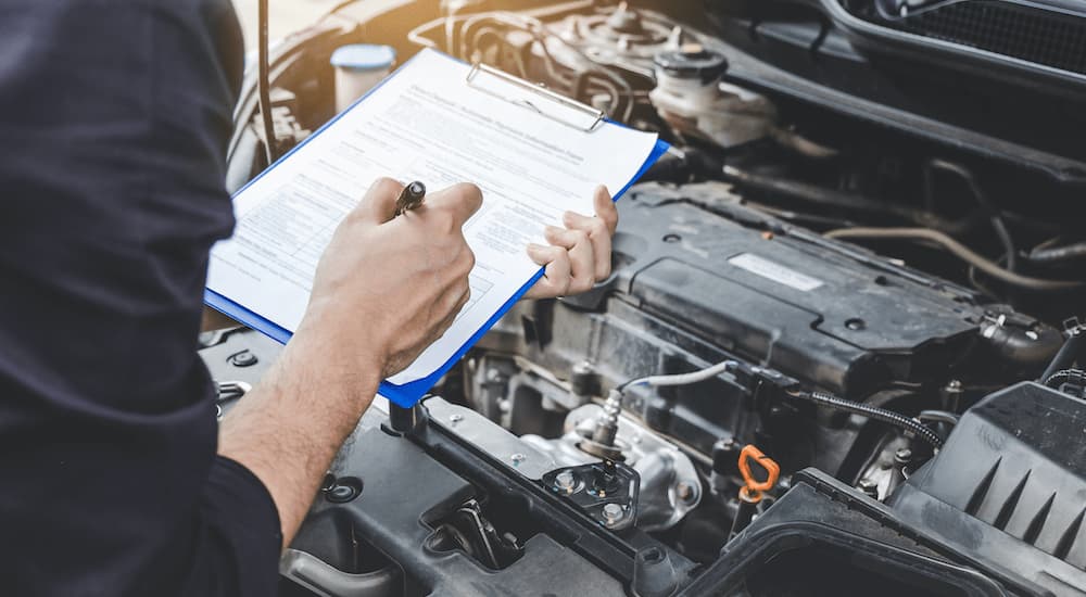 A mechanic is shown inspecting a car.