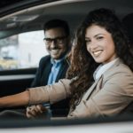 A couple is shown sitting in the front seats of a car after visiting a Certified pre-owned Ford dealer.