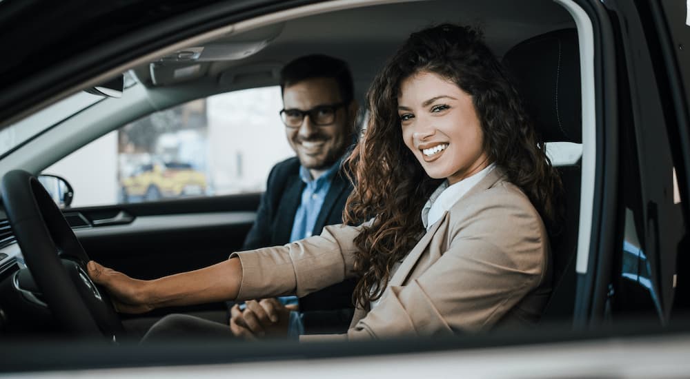 A couple is shown sitting in the front seats of a car after visiting a Certified pre-owned Ford dealer.