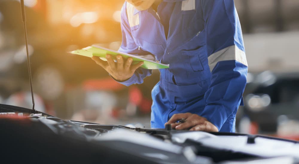 A mechanic is shown inspecting a vehicle.