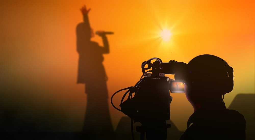 A person is shown recording a music video at a Ford dealership.