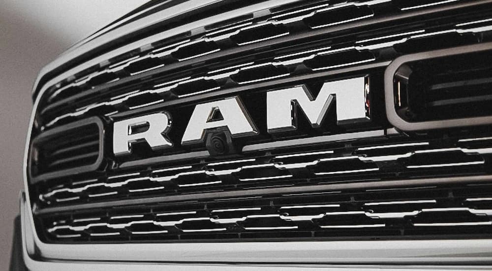 The close up of a 2022 Ram 1500 shows the grille and Ram logo.