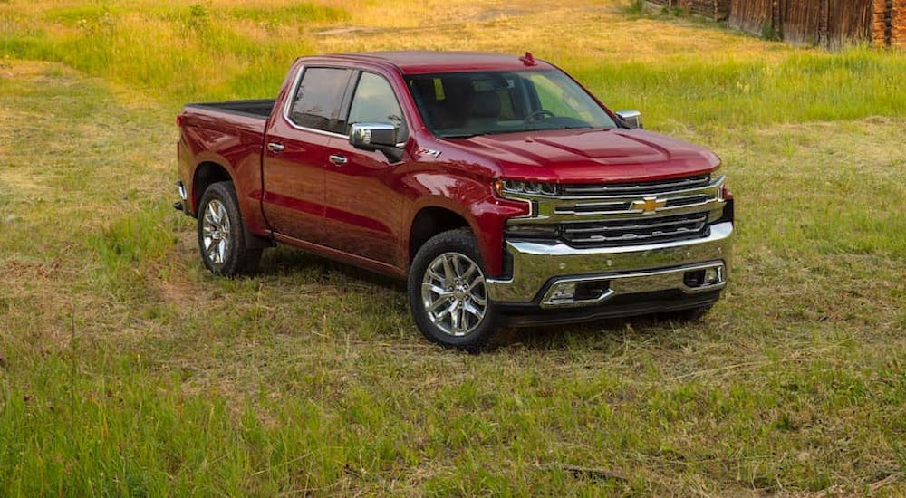 A red 2020 Chevy Silverado 1500 is shown from the front parked in a field.