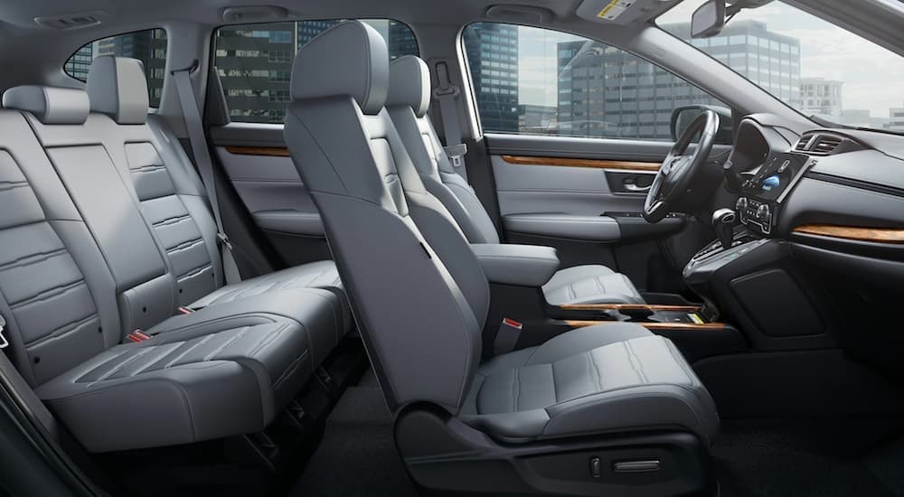 The grey interior of a 2020 Honda CR-V touring shows two rows of seating from the side.
