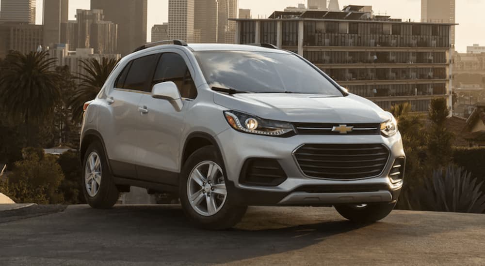 A white 2021 Chevy Trax is shown from the front parked in a city on top of a hill.