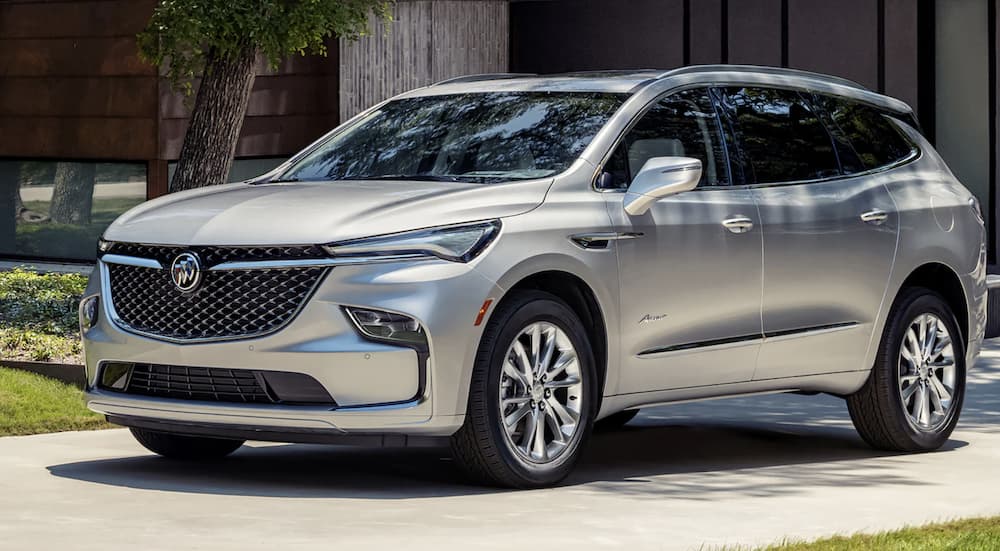 A silver 2022 Buick Enclave is shown from the side parked in front of a modern home.