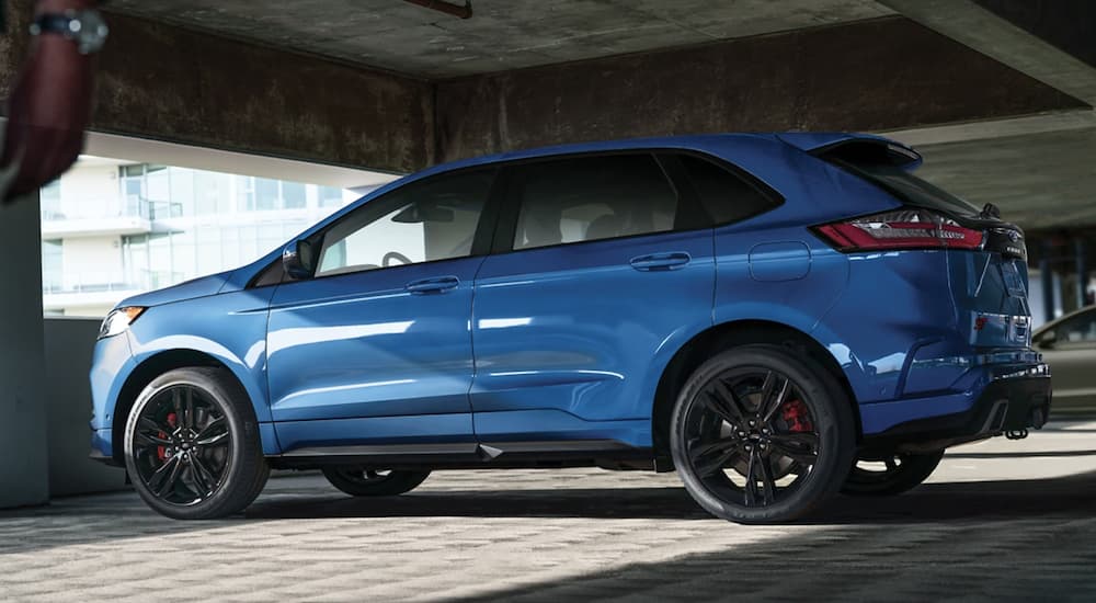 A blue 2021 Ford Edge is shown from the side parked in a parking garage.