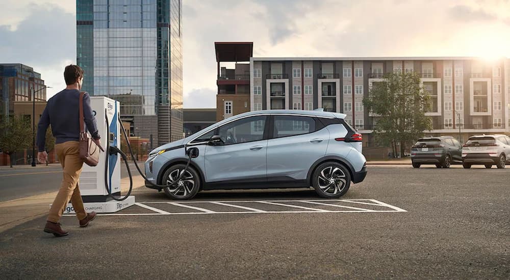 A grey 2022 Chevy Bolt EV is shown at a public charging station.