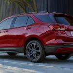 A red 2022 Chevy Equinox is shown from the rear driving on an open road.