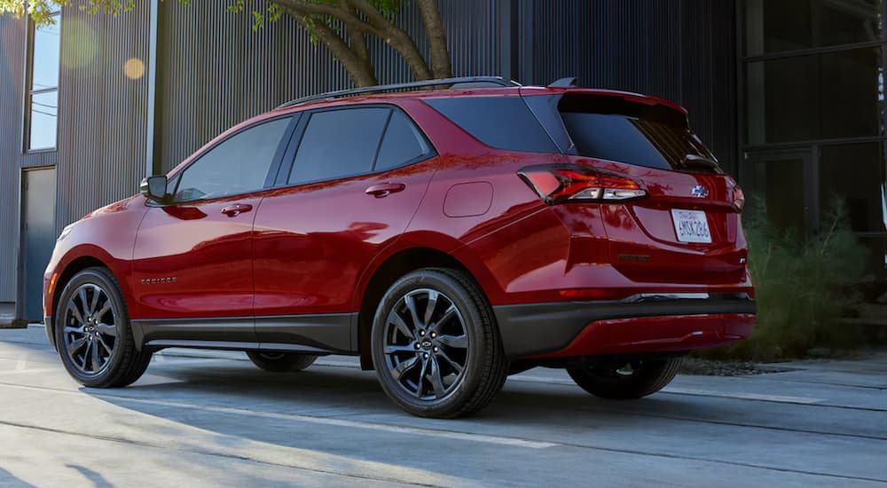 A red 2022 Chevy Equinox is shown from the rear driving on an open road.