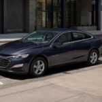 A blue 2022 Chevy Malibu is shown parked on a city street.