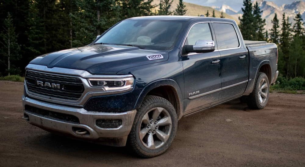 A blue 2022 Ram 1500 is shown from the side parked in the forest.
