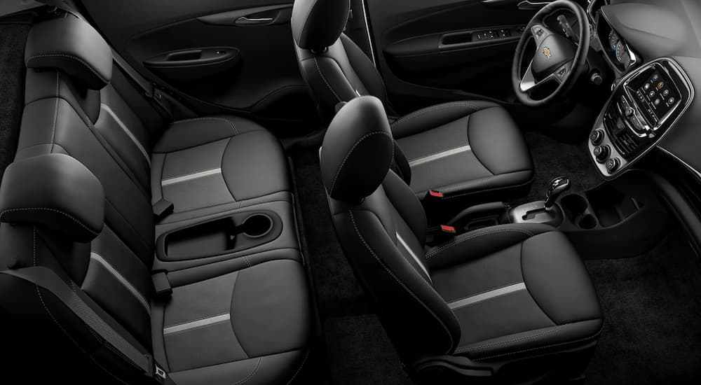 The black interior of a 2022 Chevy Spark  shows two rows of seating.