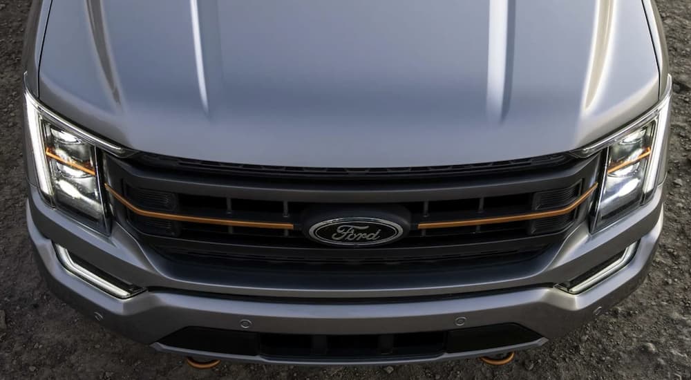 The silver hood of a 2022 Ford F-150 is shown parked during a 2022 Ford F-150 vs 2022 Chevy Silverado 1500 comparison.