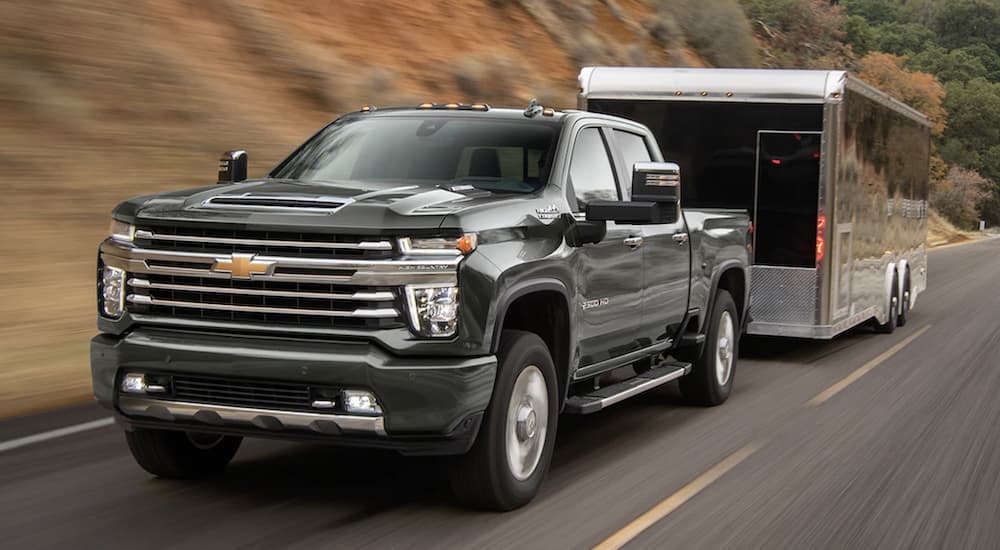 A silver 2022 GMC Sierra 2500HD is shown from the front towing a trailer.