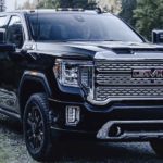 A black 2022 GMC Sierra 2500HD is shown from the front parked in the mountains.