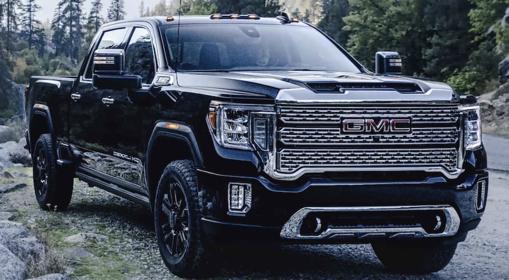 A black 2022 GMC Sierra 2500HD is shown from the front parked in the mountains.