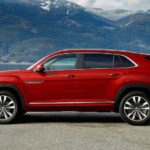 A red 2022 Volkswagen Atlas Cross Sport V6 SEL Premium R-Line is shown from the side parked in front of a lake and mountain.