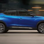 A blue 2022 Nissan Kicks is shown from the side while driving down a city street after leaving a Nissan dealer near you.