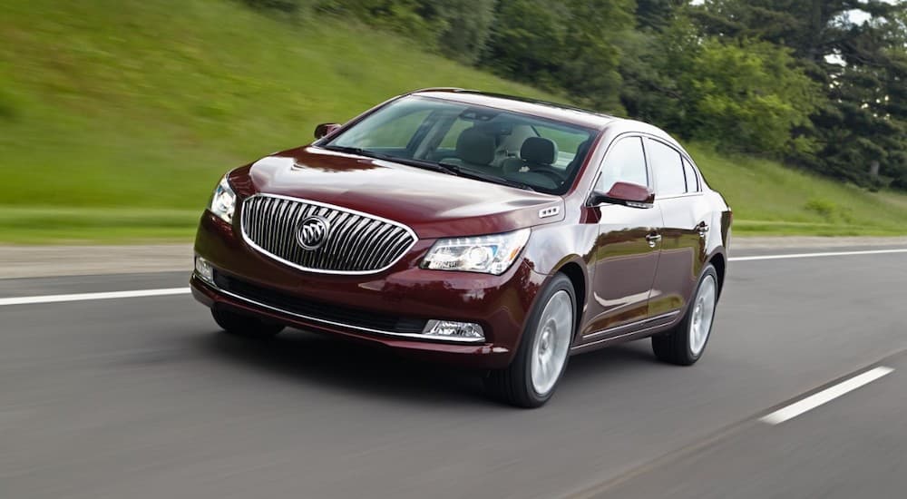 A red 2016 Buick LaCrosse is shown from the front driving on an open road.
