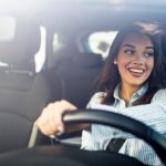 A person is shown driving a car while smiling after visiting a Certified Pre-Owned Ford dealer.