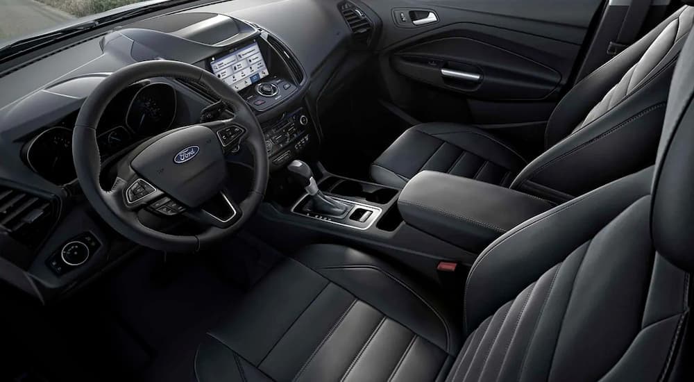A black interior of a 2019 Ford Escape shows the front seats and steering wheel.