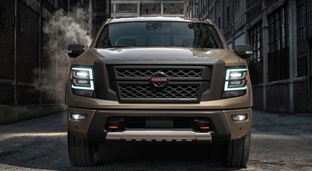 A tan 2020 Nissan Titan is shown from the front parked in an alleyway. 