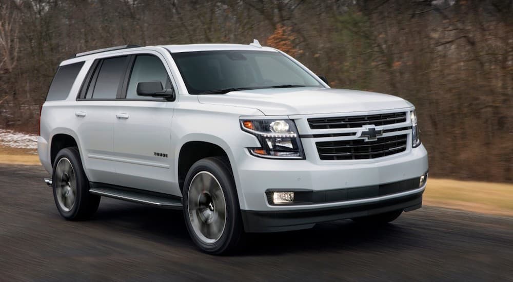A white 2018 Chevy Tahoe is shown from the front driving on an open road.
