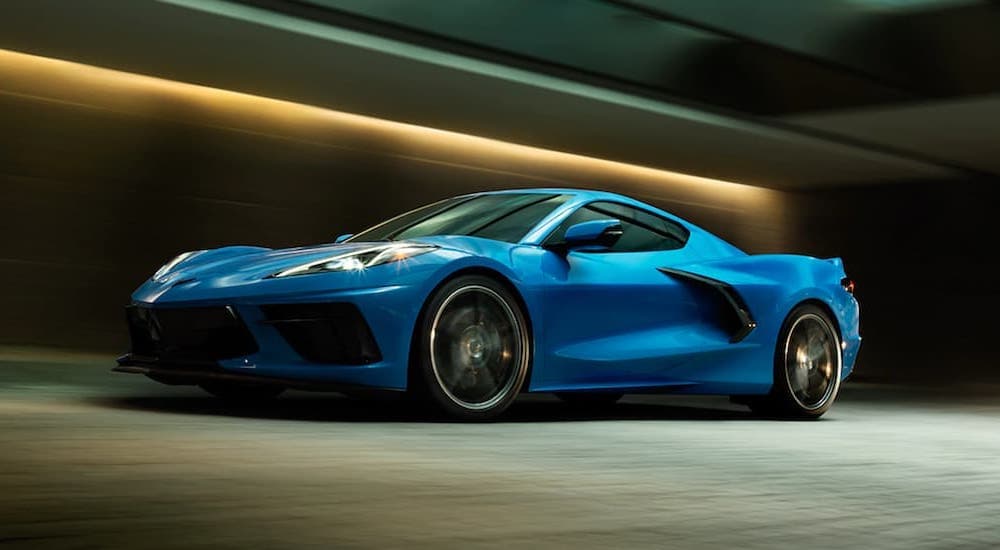A blue 2020 Chevy Corvette is shown from the side driving through a tunnel.