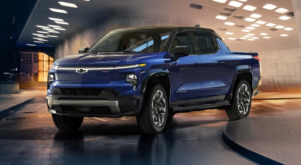 A blue 2022 Chevy Silverado EV is shown angled left at a Chevy dealer.