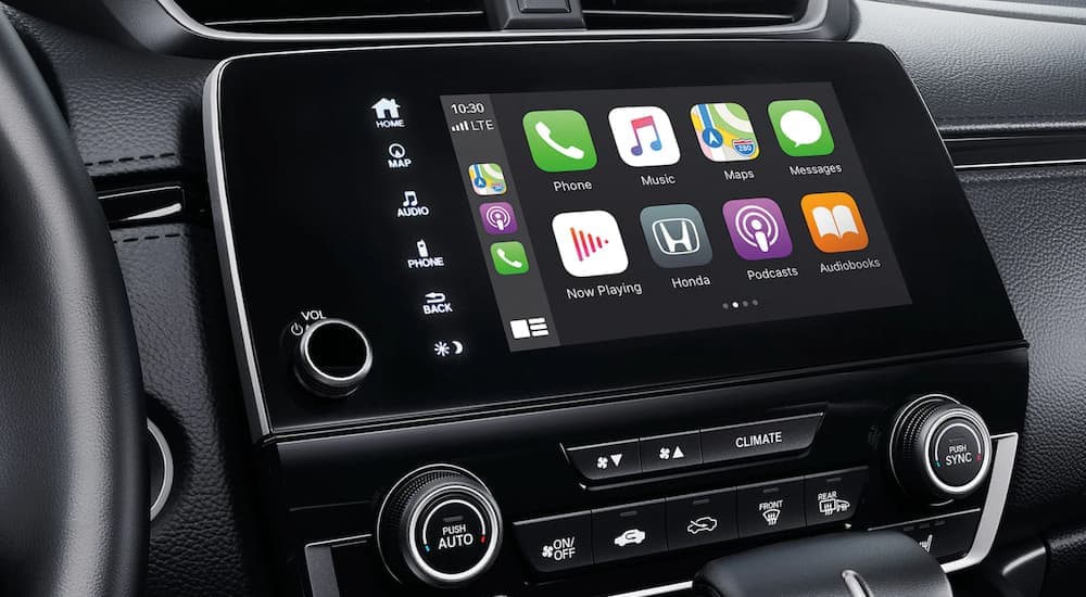 The black interior of a 2022 Honda CR-V Touring shows the infotainment screen.