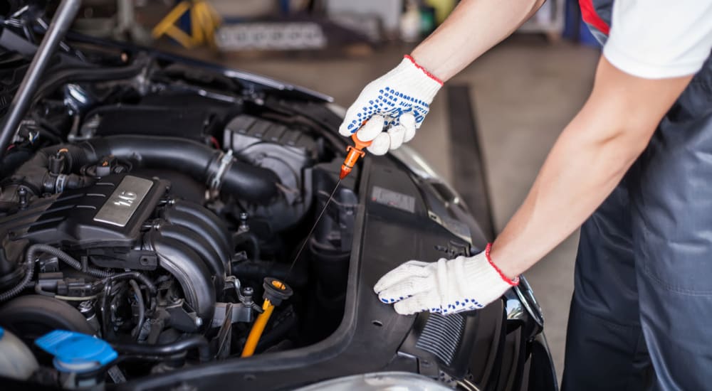 A mechanic is shown inspecting the oil stick in a vehicle.