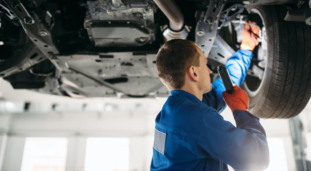 A mechanic is shown inspecting a vehicle.