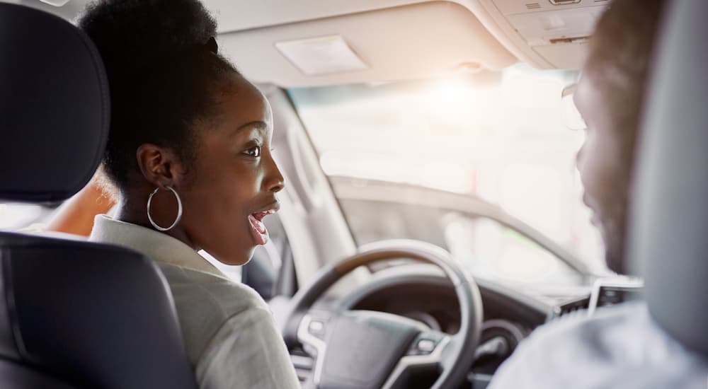 A woman is driving to a dealership after searching "sell my car."