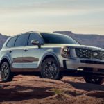 A silver 2021 used Kia Telluride is shown parked on top of a rocky hill.