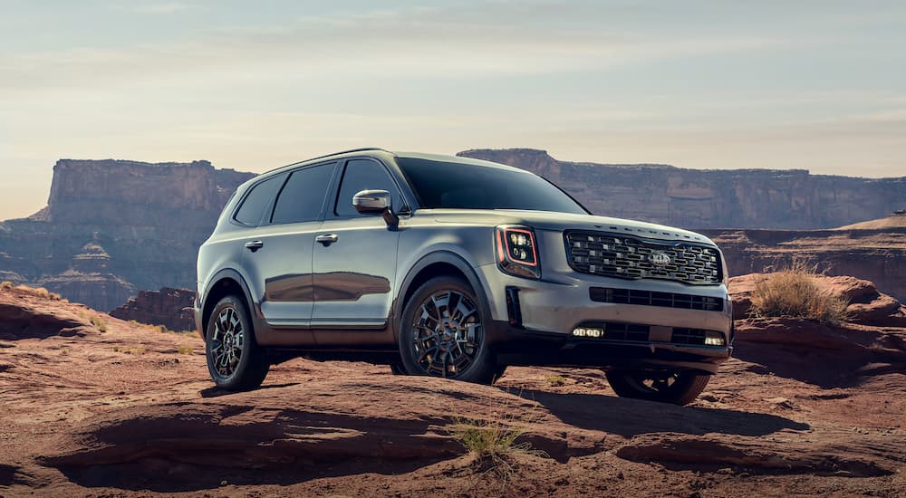 A silver 2021 used Kia Telluride is shown parked on top of a rocky hill.